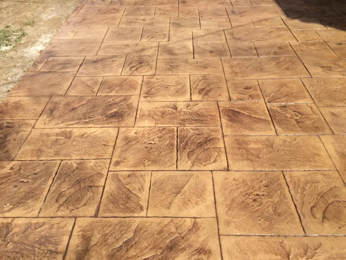 A concrete floor with some brown squares on it