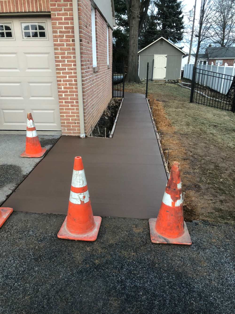 A couple of orange cones are on the sidewalk