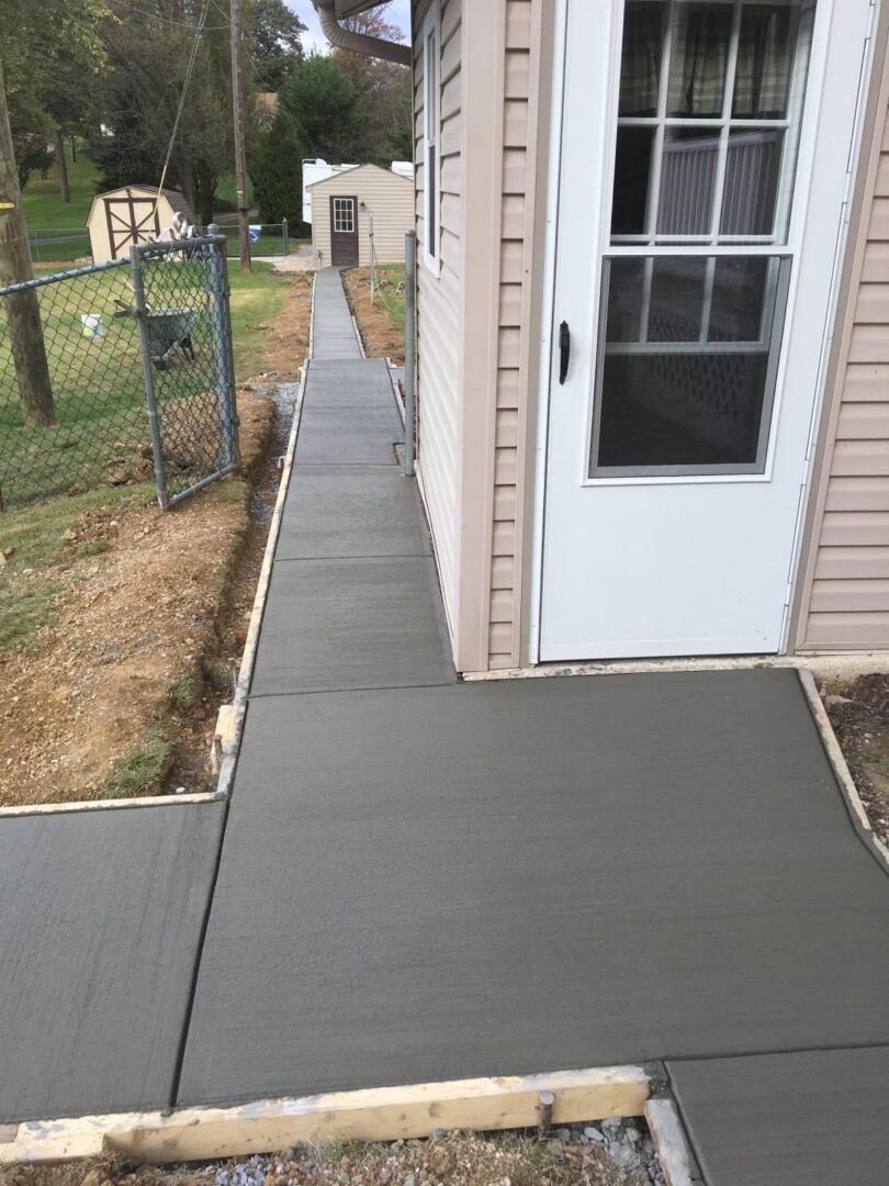 A walkway with concrete steps leading to the front door.