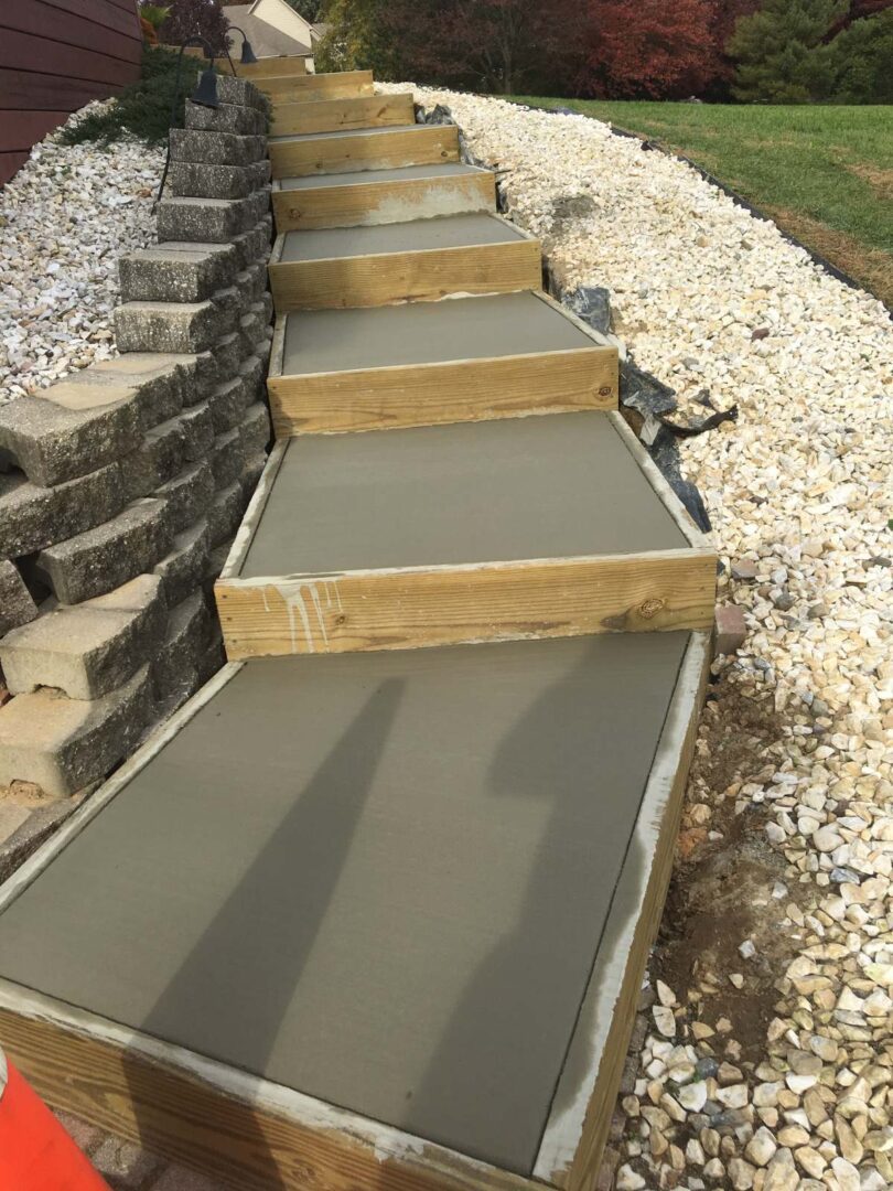 A concrete walkway with steps and gravel.