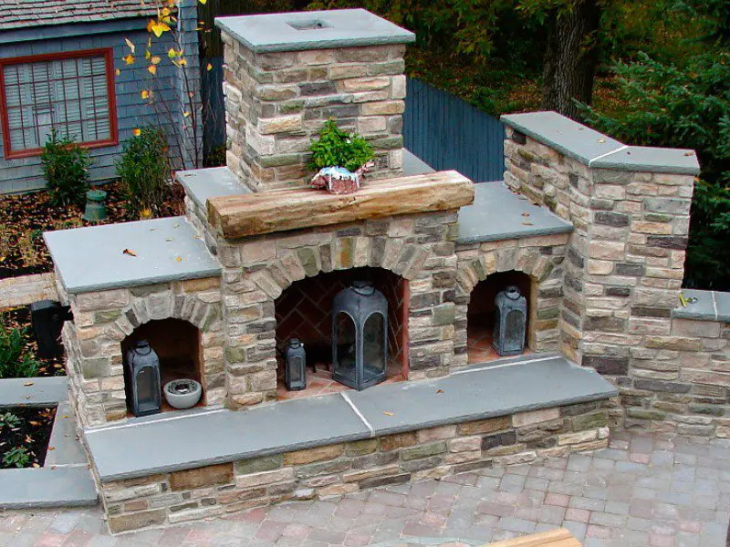 A brick fireplace with stone accents and an outdoor oven.