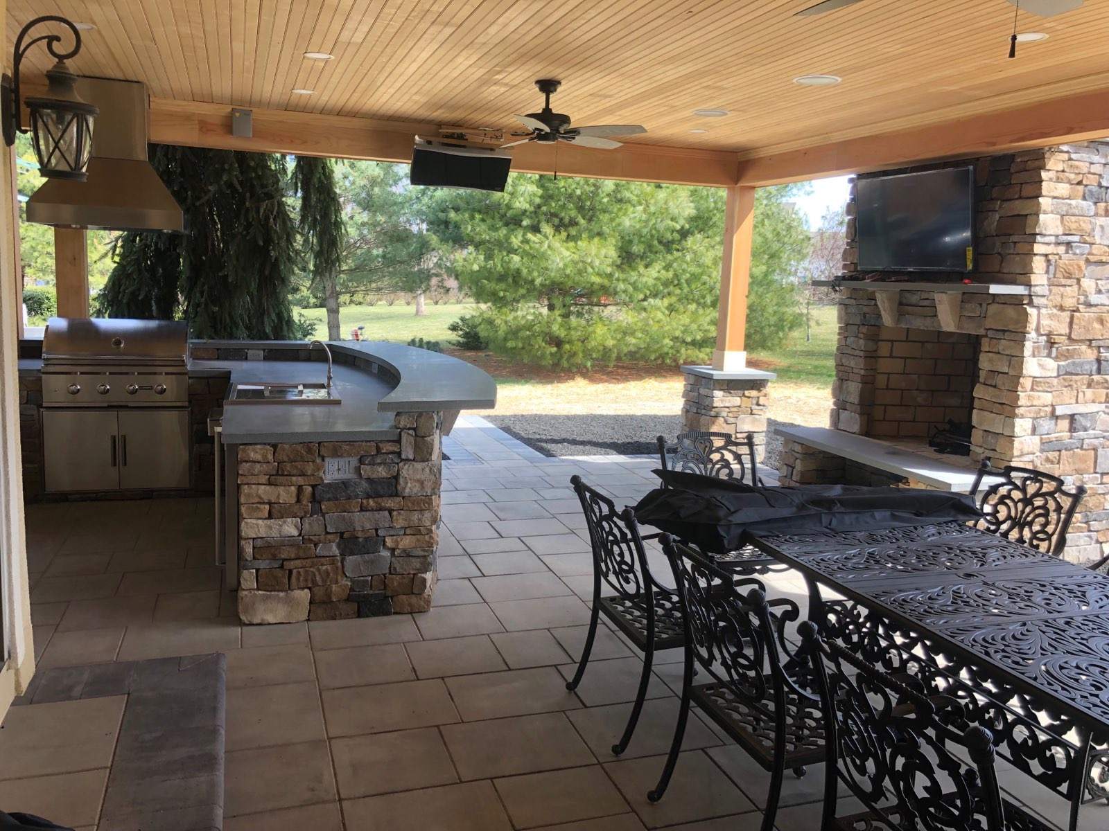 A patio with an outdoor kitchen and dining table.