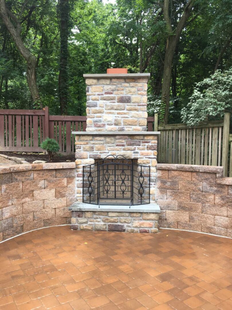 A brick fireplace with a metal gate on the side.