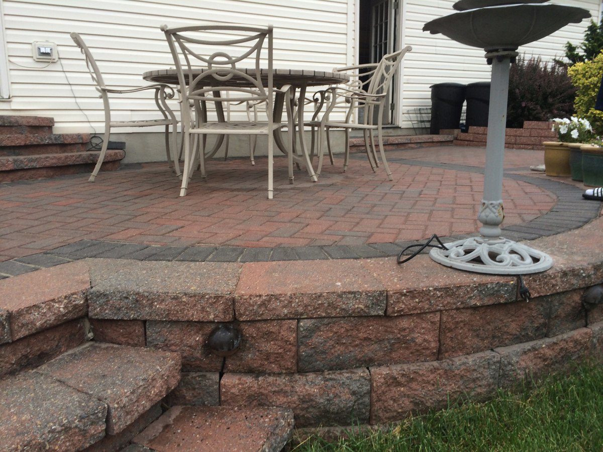 A patio with brick steps and a fire pit.