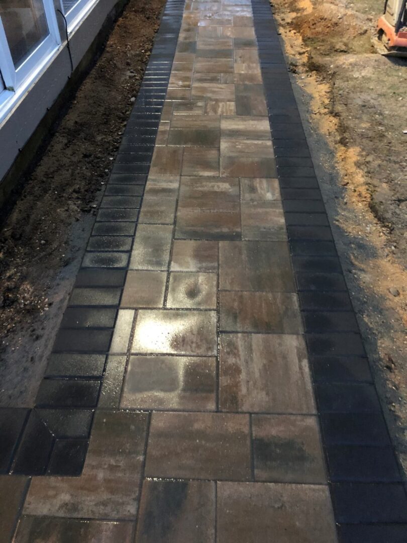 A walkway with a brick pattern and black border.