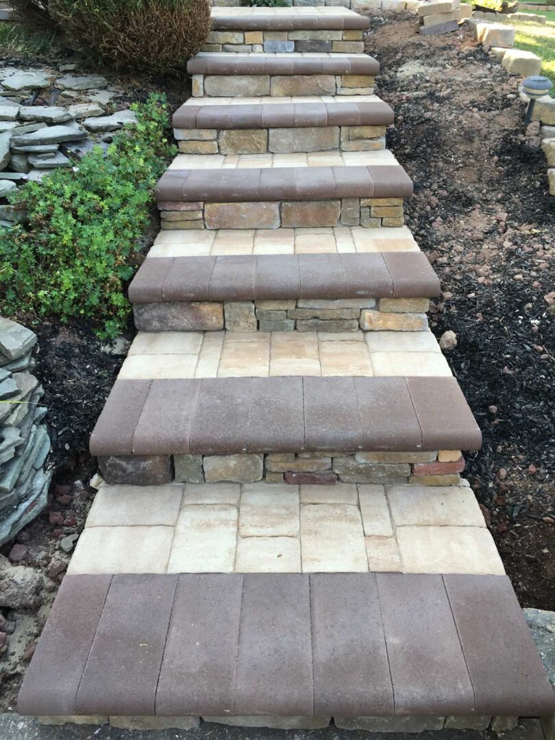 A walkway with steps and brick pavers leading to the ground.