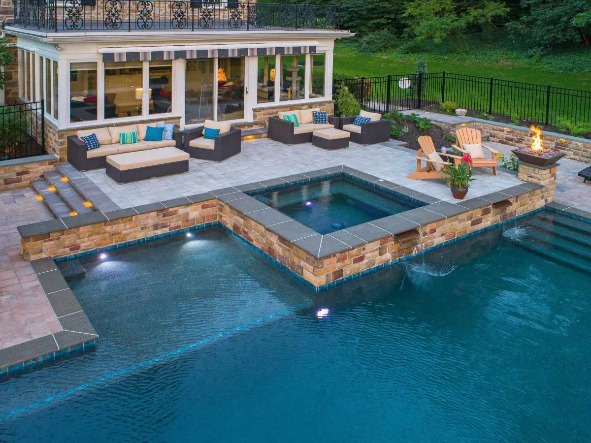 A pool with a hot tub and a deck