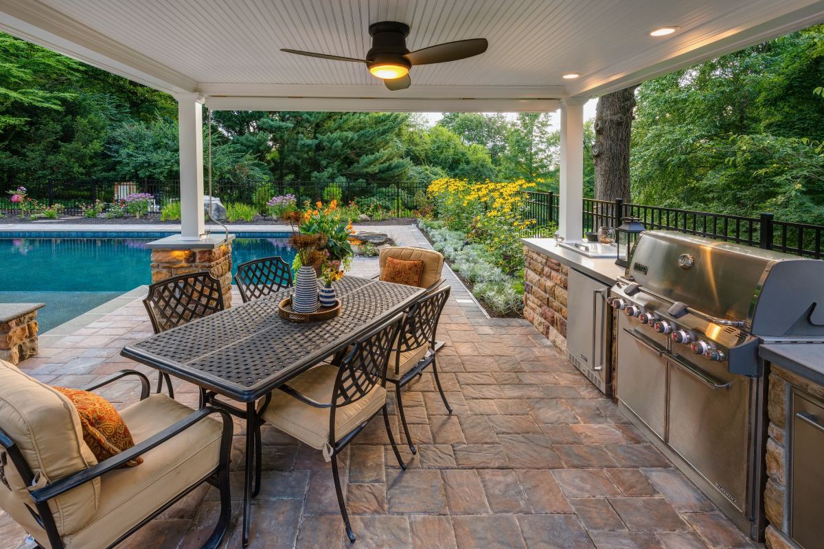 A patio with an outdoor grill and table