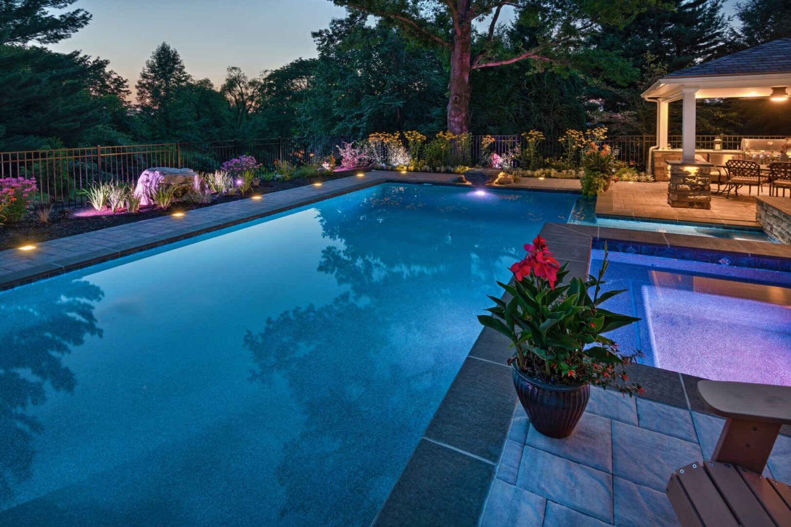 A pool with lights and plants in the middle of it