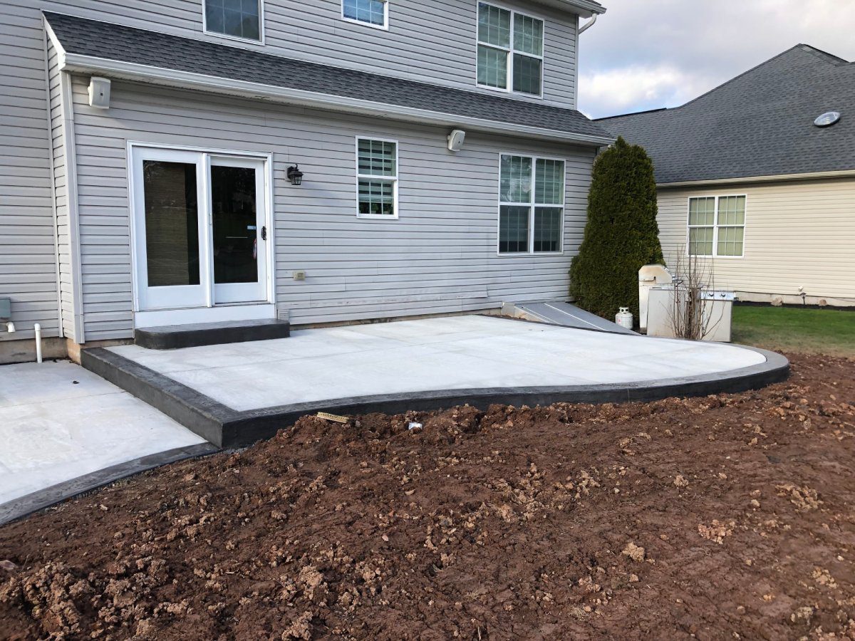 A patio with a cement slab and a concrete pad.