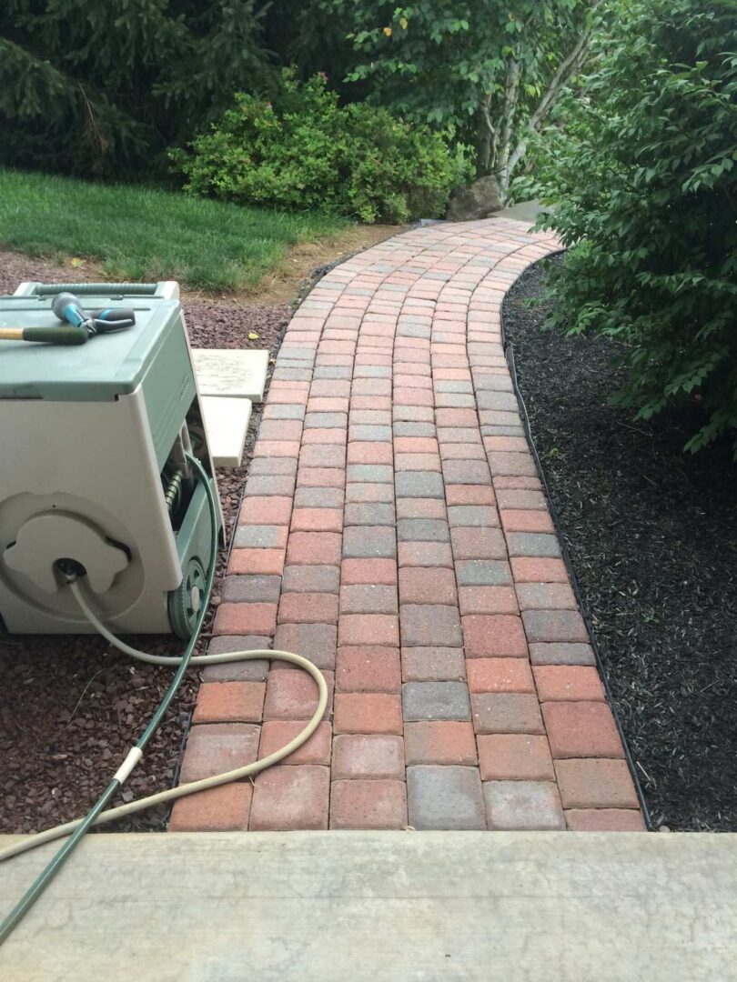 A brick walkway with a power cord attached to it.