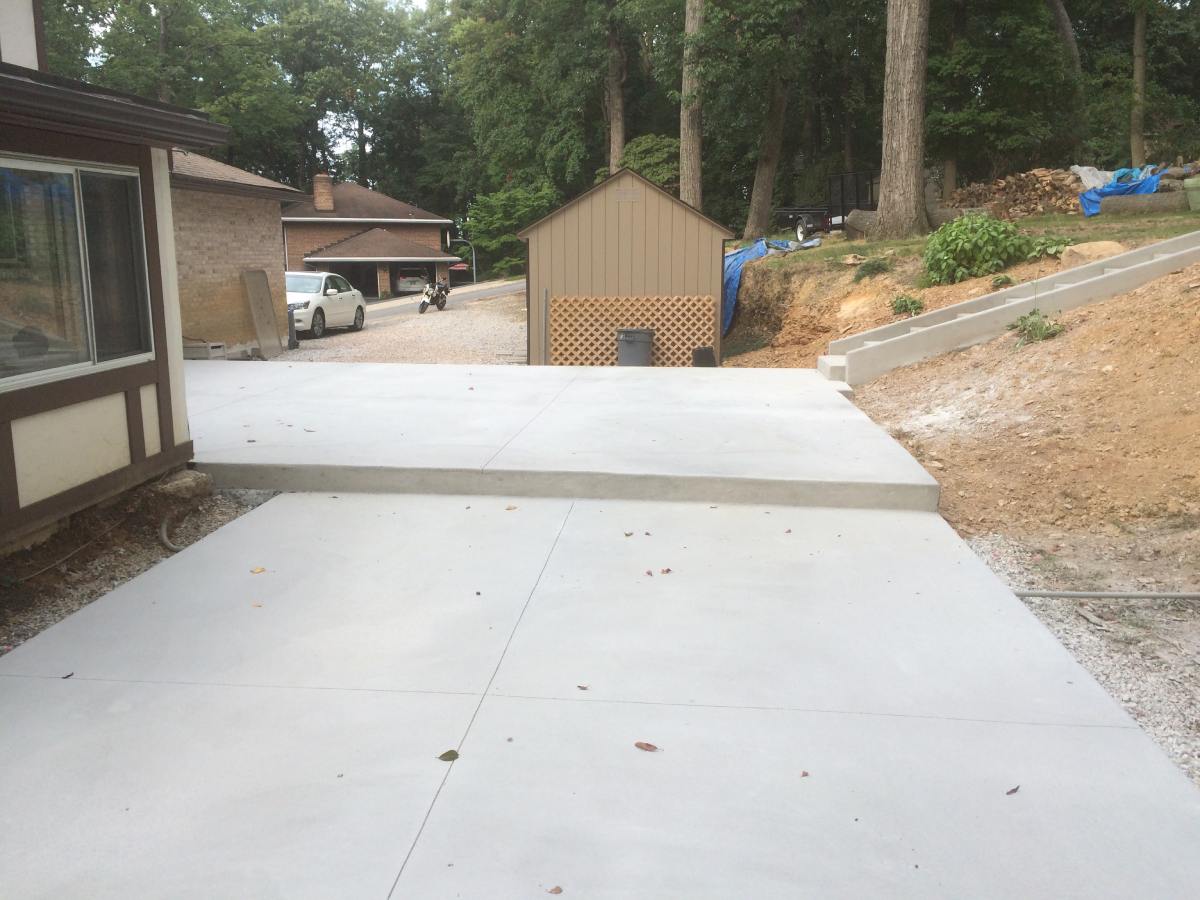 A concrete driveway with trees in the background